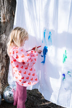 Toddler wearing Waterproof Kids Art Smock and Food Bib while painting during messy play activity