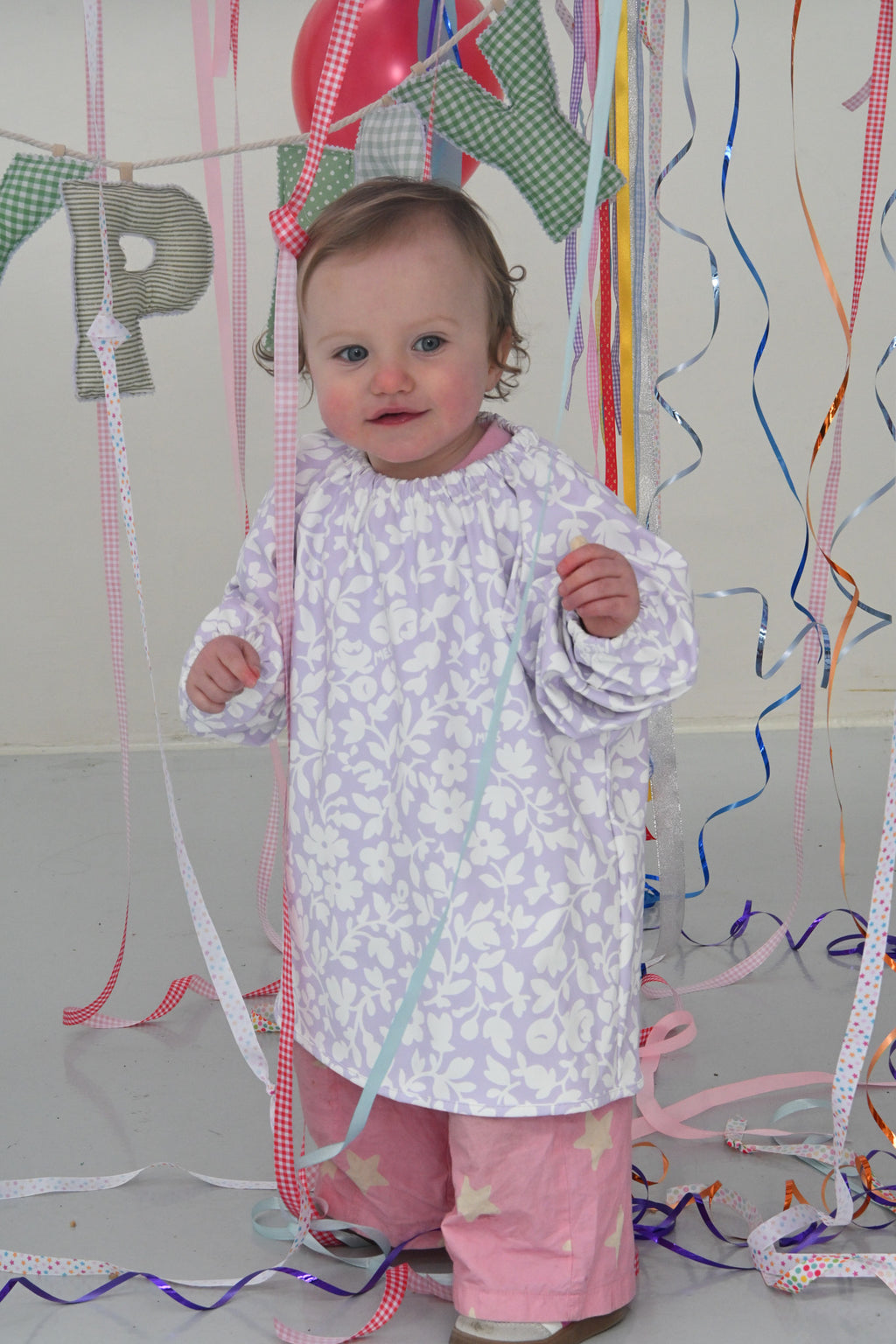 Child wearing Meadow waterproof art smock during painting activity